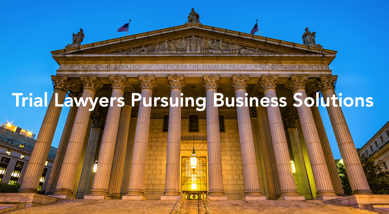 Nighttime photograph of Roman style stone courthouse with the words "Trial Lawyers Pursuing Business Solutions" superimposed in white letters over the photgraph.