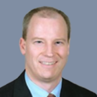 Headshot of attorney Robert Goethals with grayish blue background.