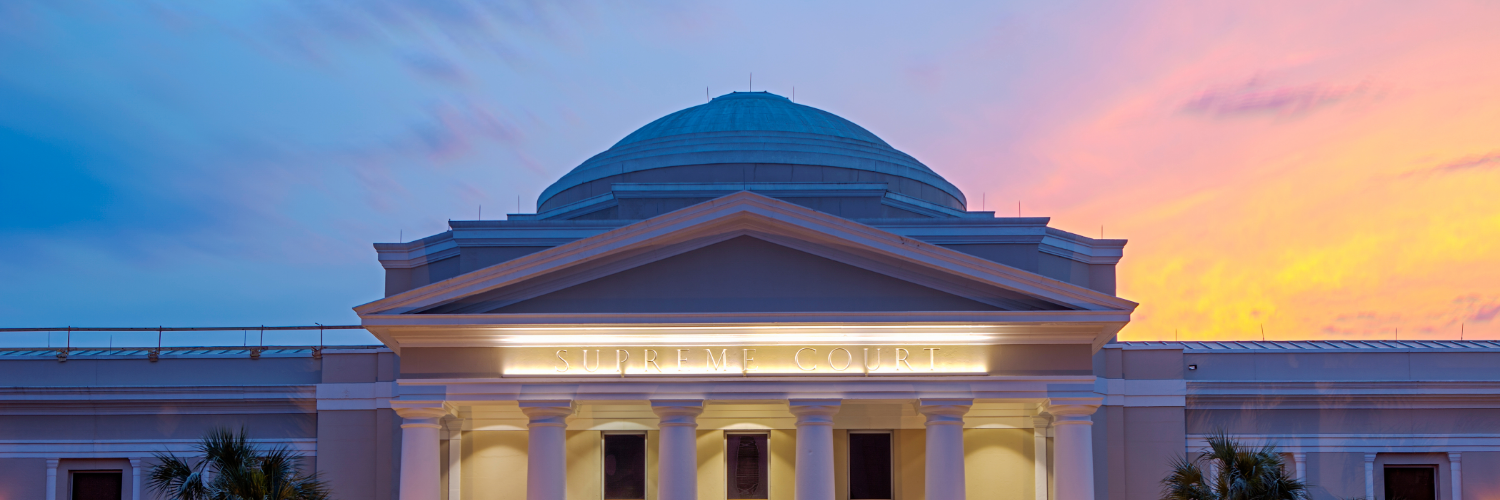 Photograph of a courthouse dome at sunset with the words "Supreme Court" engraved below the dome.