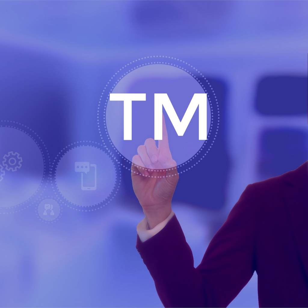 A photograph of a person pressing a button that says "TM."